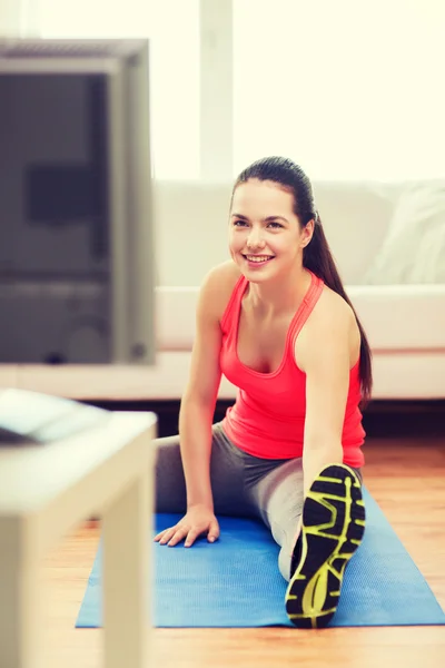 Lachende tienermeisje streching op verdieping thuis — Stockfoto