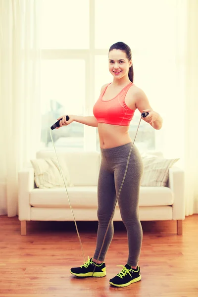 Smiling teenage girl with skipping rope at home — Stock Photo, Image