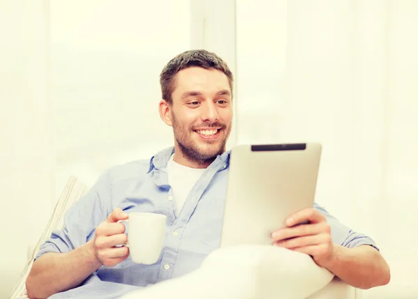 Lächelnder Mann, der zu Hause mit Tablet-PC arbeitet — Stockfoto