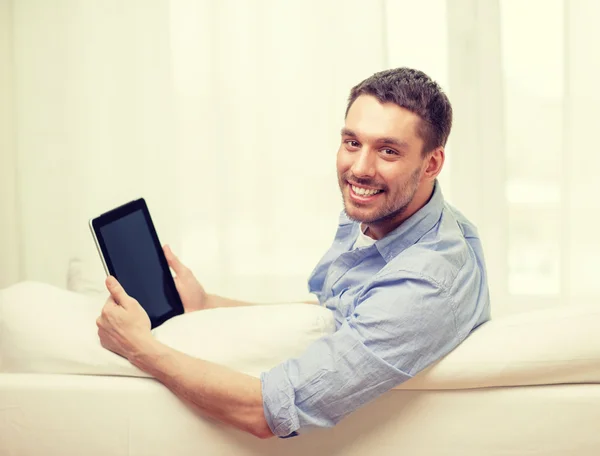 Uśmiechnięty mężczyzna pracujący z komputera typu tablet w domu — Zdjęcie stockowe