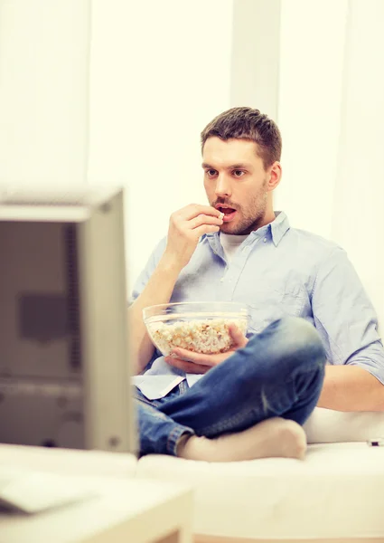 Glimlachende man kijken naar sport thuis — Stockfoto