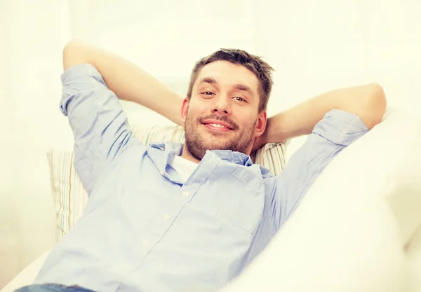 Hombre sonriente acostado en el sofá en casa — Foto de Stock