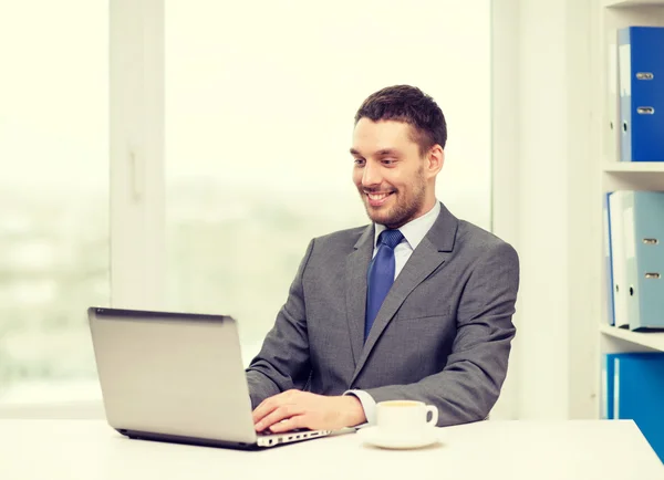 Homme d'affaires souriant avec ordinateur portable et café — Photo