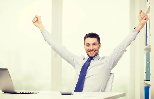 Uomo d'affari sorridente con computer portatile e documenti — Foto Stock