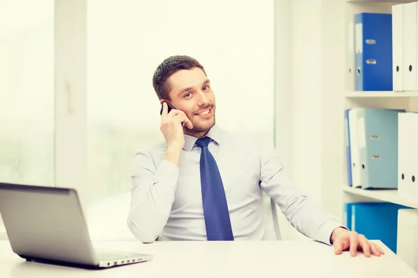 Uomo d'affari con computer portatile e smartphone in ufficio — Foto Stock