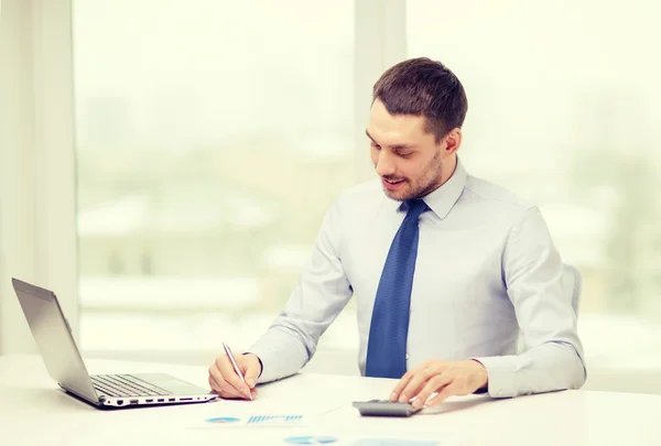 Homme d'affaires souriant avec ordinateur portable et documents — Photo