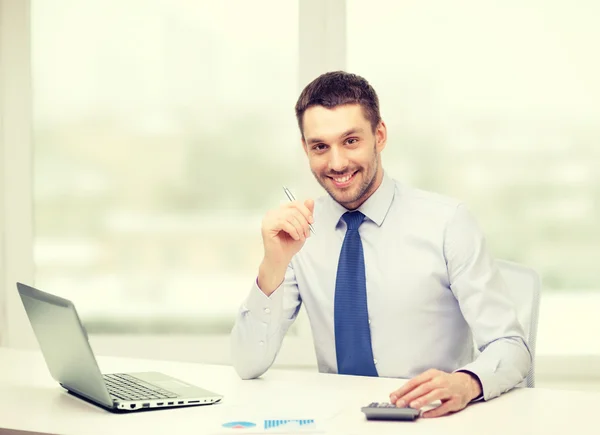 Homem de negócios sorridente com laptop e documentos — Fotografia de Stock