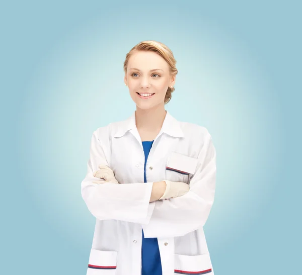 Genç kadın doktor mavi arka plan üzerinde gülümseyen — Stok fotoğraf