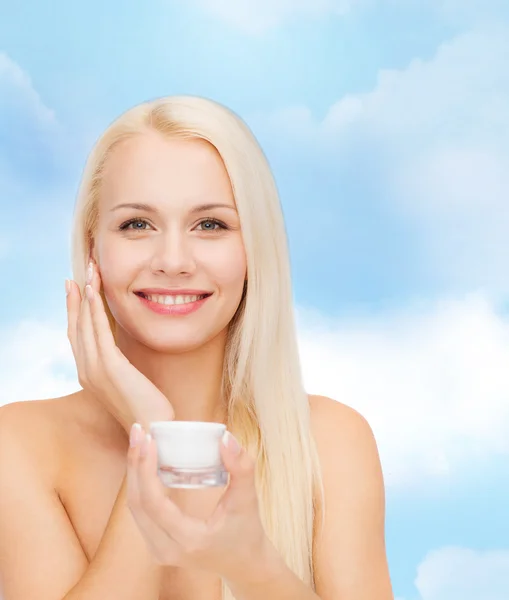 Vrouw toepassing van crème op haar huid — Stockfoto
