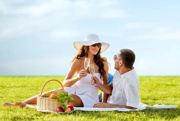 Sonriente pareja bebiendo champán en el picnic — Foto de Stock