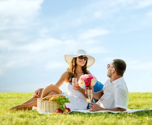 Sonriente pareja bebiendo champán en el picnic — Foto de Stock