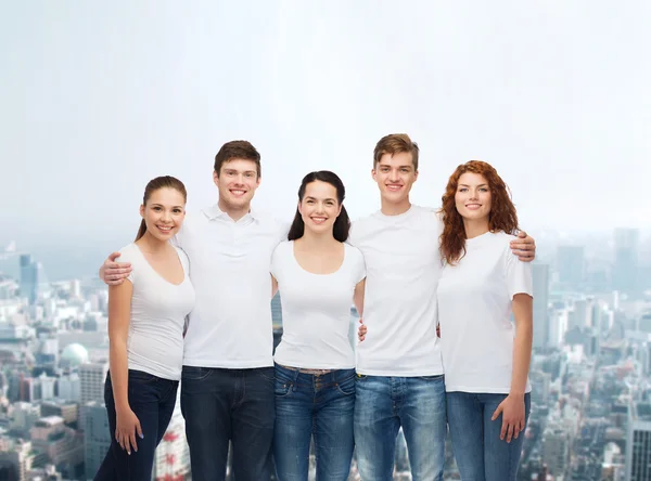 Group of smiling teenagers in white blank t-shirts — Stock Photo, Image