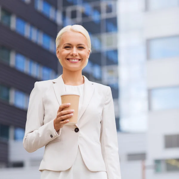 Femme d'affaires souriante avec tasse en papier à l'extérieur — Photo