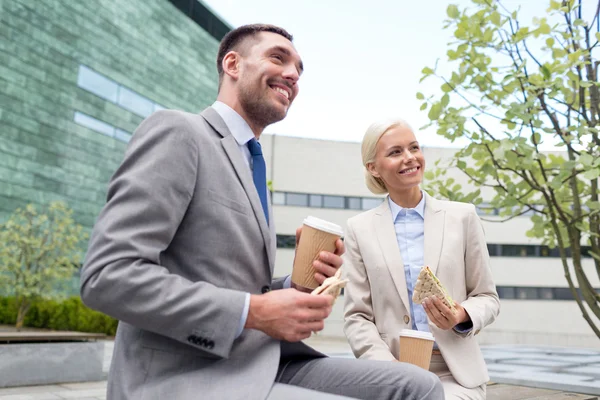 Hombres de negocios sonrientes con vasos de papel al aire libre — Foto de Stock