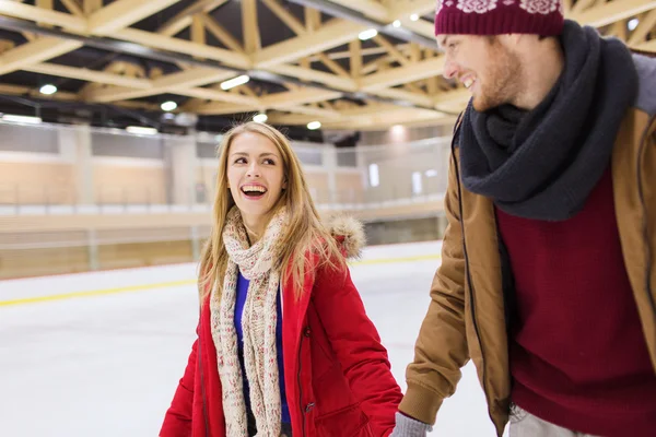 Couple heureux tenant la main sur la patinoire — Photo