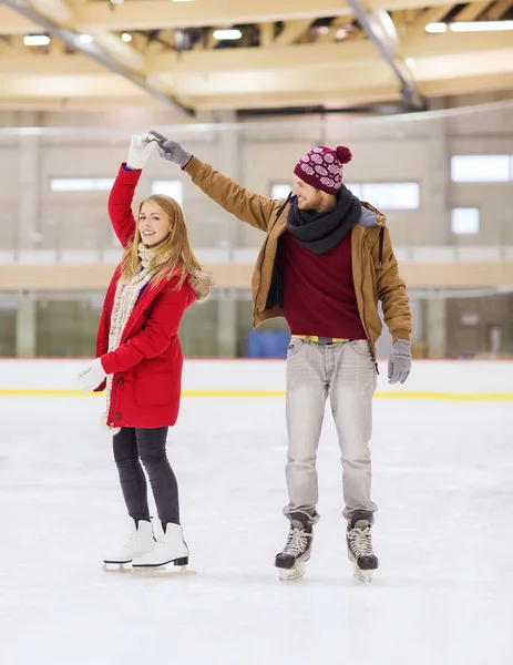 Glückliches Paar hält Händchen auf Eisbahn — Stockfoto