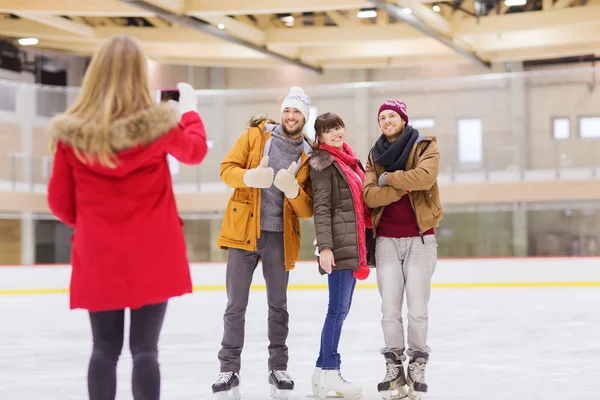 Happy friends taking photo on skating rink — Stock Photo, Image