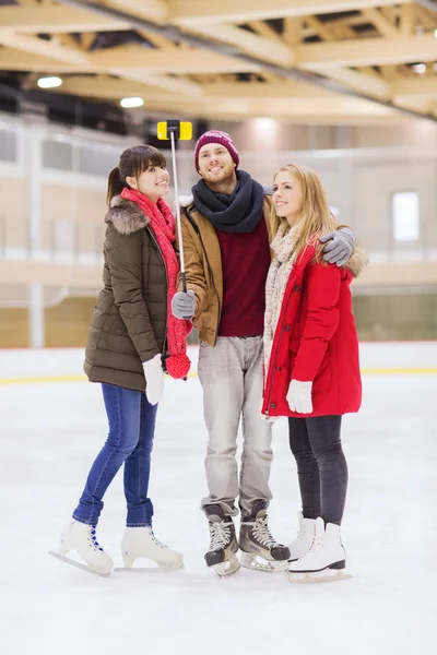 Happy friends taking selfie on skating rink — Stock Photo, Image