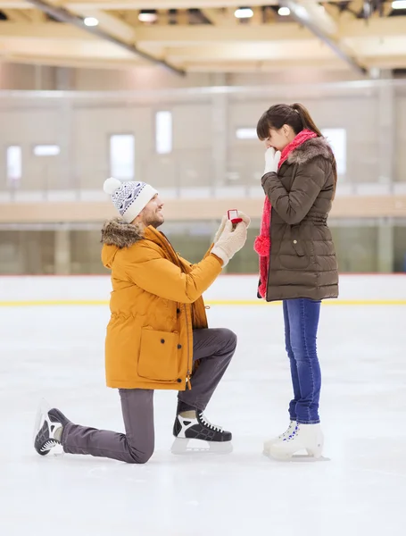 Glückliches Paar mit Verlobungsring auf Eisbahn — Stockfoto
