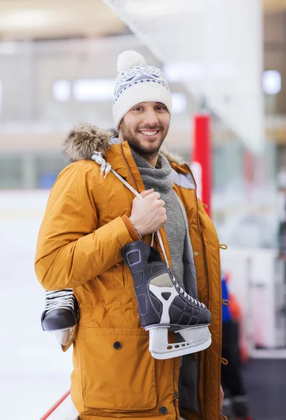 Jovem feliz com patins de gelo na pista de patinação — Fotografia de Stock