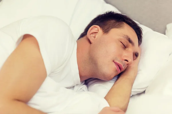 Knappe man slapen in bed — Stockfoto