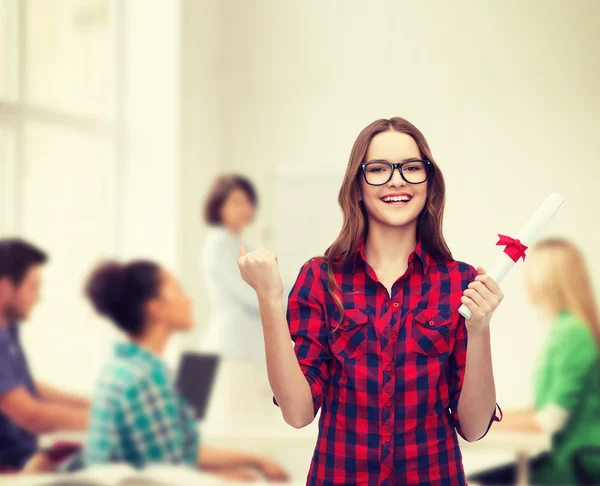 Lachende vrouwelijke student in bril met diploma — Stockfoto