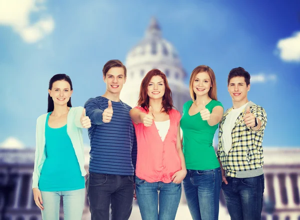 Group of smiling students showing thumbs up — Stock Photo, Image