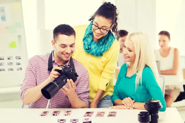 Usměvavý tým s fotokamery pracující v kanceláři — Stock fotografie