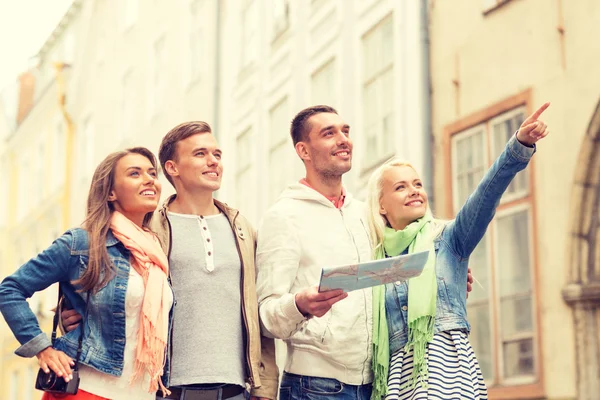 Gruppe lächelnder Freunde mit Karte und Fotokamera — Stockfoto