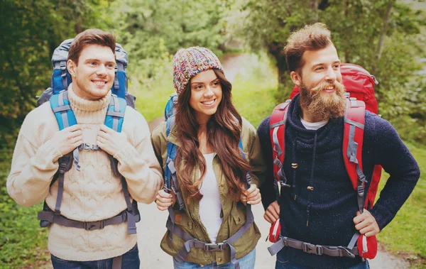 Gruppe lächelnder Freunde mit Rucksäcken beim Wandern — Stockfoto