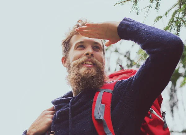 Homem sorridente com barba e mochila caminhadas — Fotografia de Stock