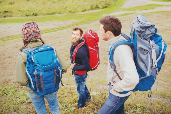 Grupo de amigos sonrientes con mochilas senderismo — Foto de Stock