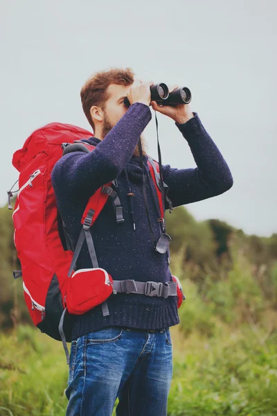 Man with backpack and binocular outdoors — Stock Photo, Image