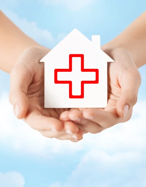 Hands holding paper house with red cross — Stock Photo, Image