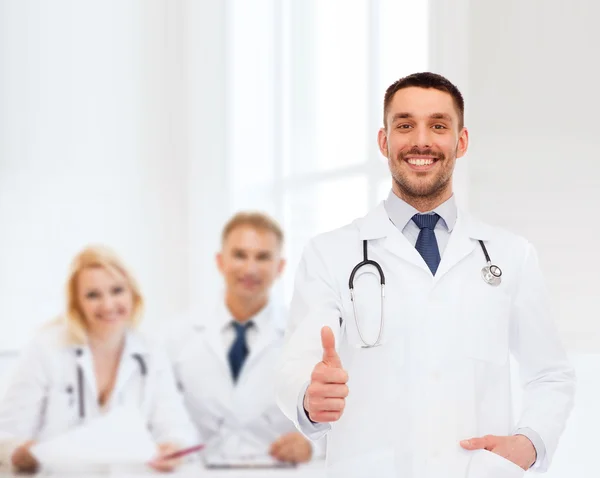 Усміхнений лікар зі стетоскопом, що показує великі пальці вгору — стокове фото