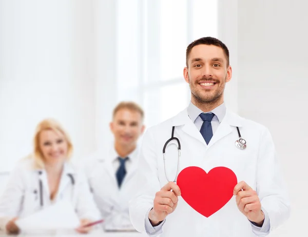 Sorridente médico masculino com coração vermelho — Fotografia de Stock