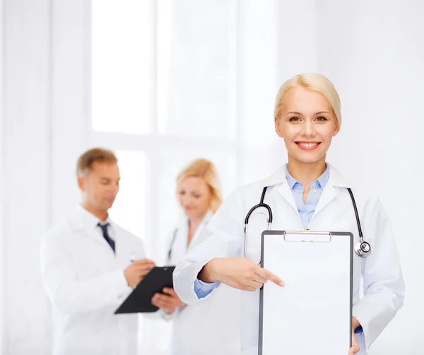 Médica sorridente com prancheta — Fotografia de Stock