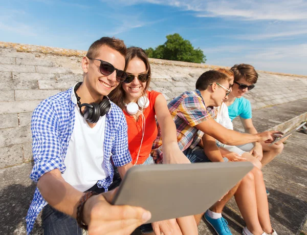 Grupo de amigos sorridentes com tablet pc ao ar livre — Fotografia de Stock