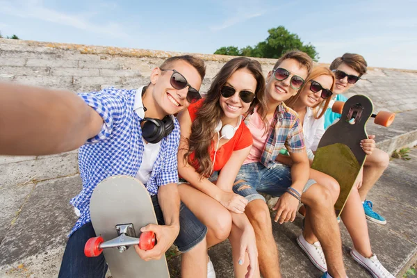 Grupo de amigos sonrientes con teléfono inteligente al aire libre — Foto de Stock