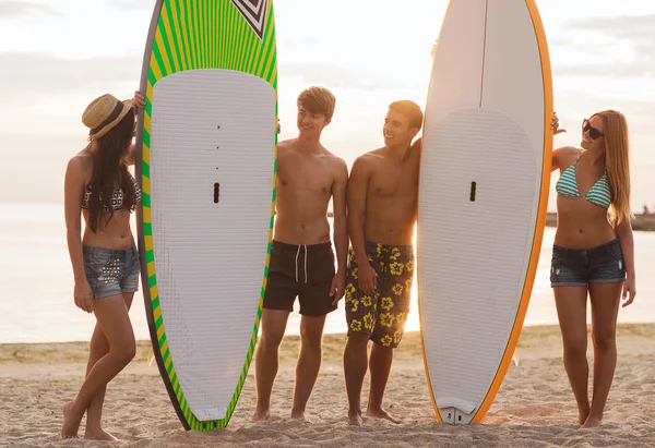 Lachende vrienden in zonnebril met surft op strand — Stockfoto