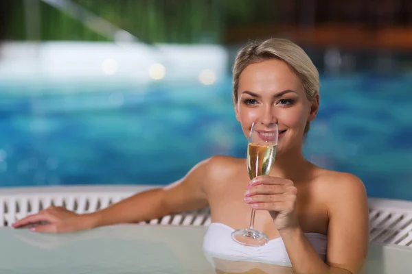 Mujer feliz bebiendo champán en la piscina —  Fotos de Stock