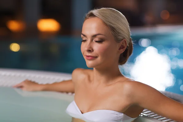 Szczęśliwy womani siedzi w jacuzzi w basenie — Zdjęcie stockowe