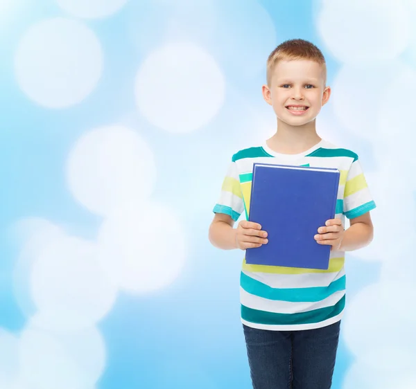 Petit garçon étudiant souriant avec livre bleu — Photo