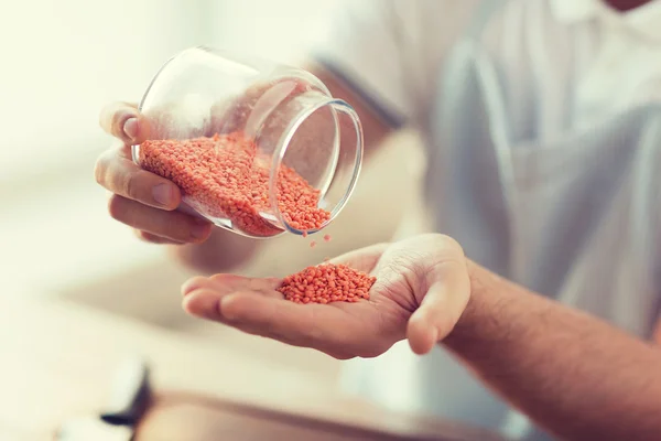 Primo piano del vaso di svuotamento maschile con lenticchie rosse — Foto Stock