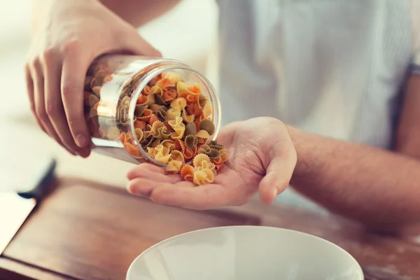 Primo piano del vaso di svuotamento maschile con pasta colorata — Foto Stock