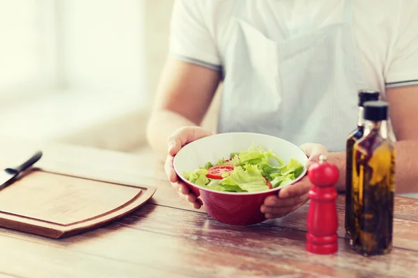 Fechar da mão masculina segurando uma tigela com salada — Fotografia de Stock