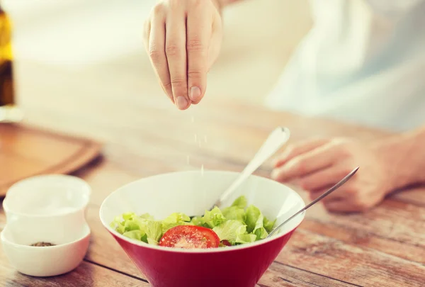 Großaufnahme männlicher Hände, die Salat in einer Schüssel würzen — Stockfoto