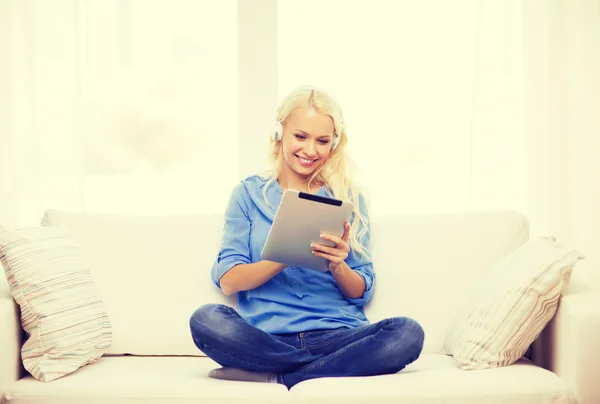 Mulher com tablet pc e fones de ouvido em casa — Fotografia de Stock