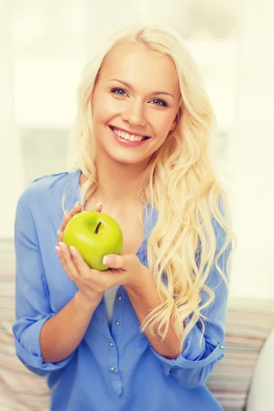 Lächelnde Frau mit grünem Apfel zu Hause — Stockfoto