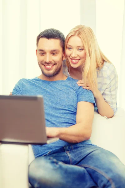 Улыбающаяся счастливая пара с ноутбуком дома — стоковое фото